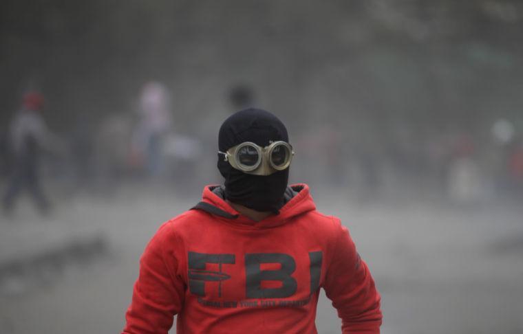 An Egyptian protester part of the Black Bloc, clashes with riot police, not seen, near Tahrir Square, Cairo, Egypt, Monday, Jan. 28, 2013. An unpredictable new element has entered Egypt&#8217;s wave of political unrest, a mysterious group of black-masked young men calling themselves the Black Bloc. They present themselves as the defenders of protesters against the rule of President Mohammed Morsi, but Islamists have used them to depict the opposition as a violent force wrecking the nation. (AP Photo/Khalil Hamra)
 