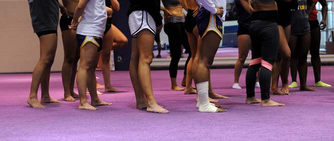 The LSU gymnastics team, one with a wrapped ankle, stand Monday, Jan. 28, 2013 on the gym floor during practice.
 