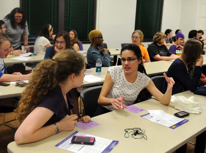 Anthropology sophomore, Regina Schneider (right), participates in an ice breaker activity on Monday, Jan. 28, 2013 at a meeting for the Geography and Anthropology Society in the Howe Russell Geoscience Complex.
 