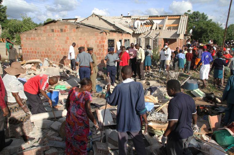 Zimbabwean police, centre, attend to the scene of an explosion in Chitungwiza about 30 kilometres east of Harare, Tuesday, Jan. 22, 2013. The blast which occurred on Monday caused extensive damage to several houses killing 5 people in the process. The reason for the explosion is not known. (AP Photo/Tsvangirayi Mukwazhi)
 