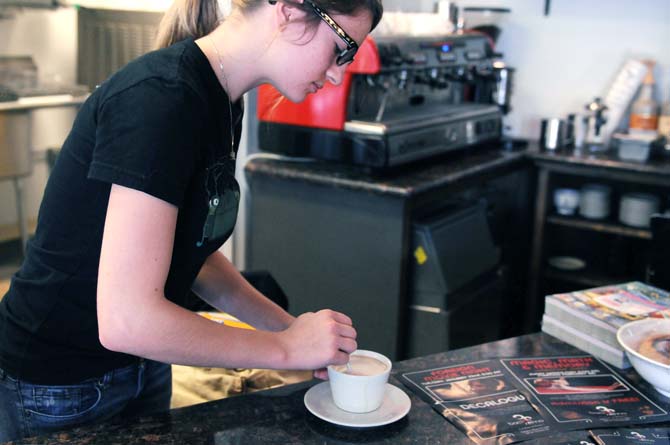 Kristin Amant, a sophomore apparel design student, stirs a cappuccino while on shift at Bacio di Roma on Saturday, Jan. 19.
 