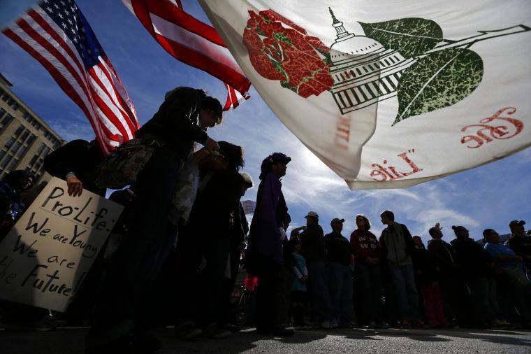 A flag that flew at a Washington DC anti-abortion rally waves in the wind as thousands gathered for the Rally for Life outside the Earle Cabell Federal Courthouse, site of the landmark Roe v Wade lawsuit filing over 40 years ago, in downtown Dallas, Saturday, Jan. 19, 2013. The anti-abortion rally marks the 40th anniversary of Roe v. Wade, the Supreme Court decision that legalized abortion. Between 8,000-10,000 anti-abortion supporters gathered for the March for Life from the Cathedral Guadalupe to the Earle Cabell Federal Courthouse. (AP Photo/The Dallas Morning News, Tom Fox)
 