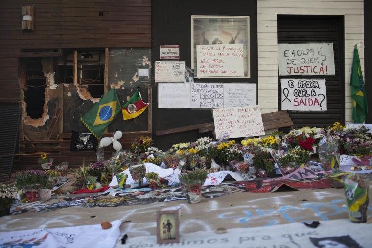 Posters, flowers, balloons and flags make up part of a makeshift memorial outside the Kiss nightclub in Santa Maria, Brazil, Wednesday, Jan. 30, 2013. A fast-moving fire roared through the crowded, windowless nightclub in this southern Brazilian city early Sunday, killing more than 230 people. Most of the dead were college students 18 to 21 years old, but they also included some minors. Almost all died from smoke inhalation rather than burns. The blaze was the deadliest in Brazil since at least 1961, when a fire that swept through a circus killed 503 people in Niteroi, Rio de Janeiro. (AP Photo/Felipe Dana)
 