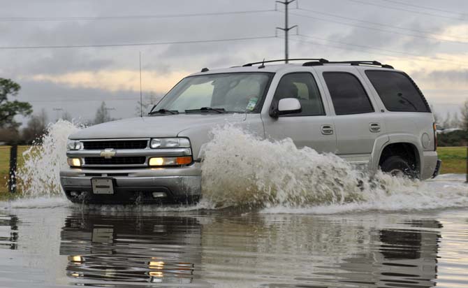 An SUV drives Thursday, Jan. 10, 2013 through the flooded road near the corner of Burbank Drive and Nicholson Drive.
 