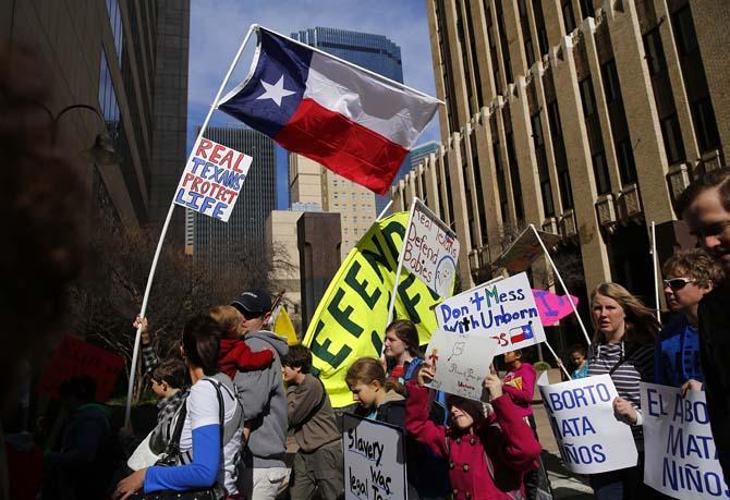 Anti-abortion supporters parade down Jackson St. during the March for Life in downtown Dallas, Saturday, Jan. 19, 2013 to mark the 40th anniversary of Roe v. Wade, the Supreme Court decision that legalized abortion. Between 8,000-10,000 anti-abortion supporters gathered for the March for Life from the Cathedral Guadalupe to the Earle Cabell Federal Courthouse, site of the landmark Roe v Wade lawsuit filing over 40 years ago in Dallas. (AP Photo/The Dallas Morning News, Tom Fox)
 