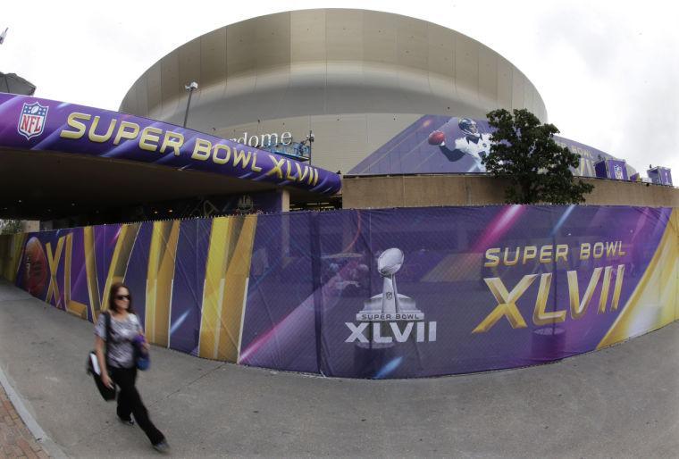 A pedestrian walks past the Superdome where the San Francisco 49ers and the Baltimore Ravens will play the NFL Super Bowl XLVII football game, Tuesday, Jan. 29, 2013, in New Orleans. (AP Photo/Charlie Riedel)
 