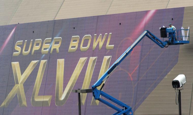 A person works on the Super Bowl sign at the Superdome in New Orleans on Monday, Jan. 14, 2013. NFL football's Super Bowl XLVII is scheduled for Sunday, Feb. 3, in New Orleans. (AP Photo/Janet McConnaughey)
 