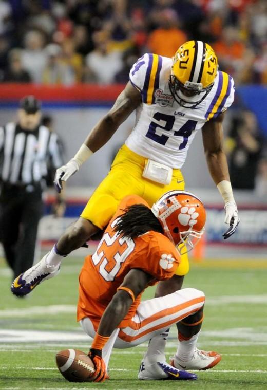 LSU junior cornerback Tharold Simon (24) towers over Clemson senior running back Andre Ellington (23) Dec. 31, 2012 after a tackle during LSU's 24-25 Chick-fil-A Bowl loss in Atlanta, Ga.
 