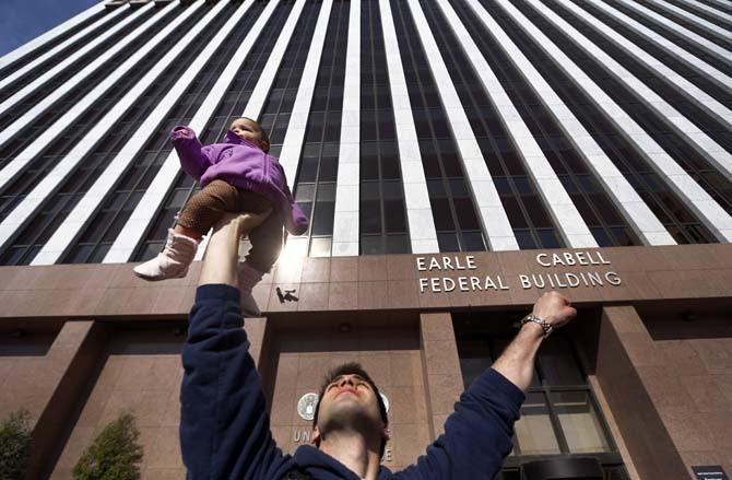 Anti-abortion supporter Chris Blackwell of Richardson, Texas says, "Everyone is holding a sign, I'm holding up a baby," referring to his 8-month-old daughter, Felicity, during the Rally for Life outside the Earle Cabell Federal Courthouse, site of the landmark Roe v Wade lawsuit filing, in downtown Dallas, Saturday, Jan. 19, 2013. The rally marks the 40th anniversary of Roe v. Wade, the Supreme Court decision that legalized abortion. Between 8,000-10,000 anti-abortion supporters gathered for the March for Life from the Cathedral Guadalupe to the Earle Cabell Federal Courthouse. (AP Photo/The Dallas Morning News, Tom Fox)
 