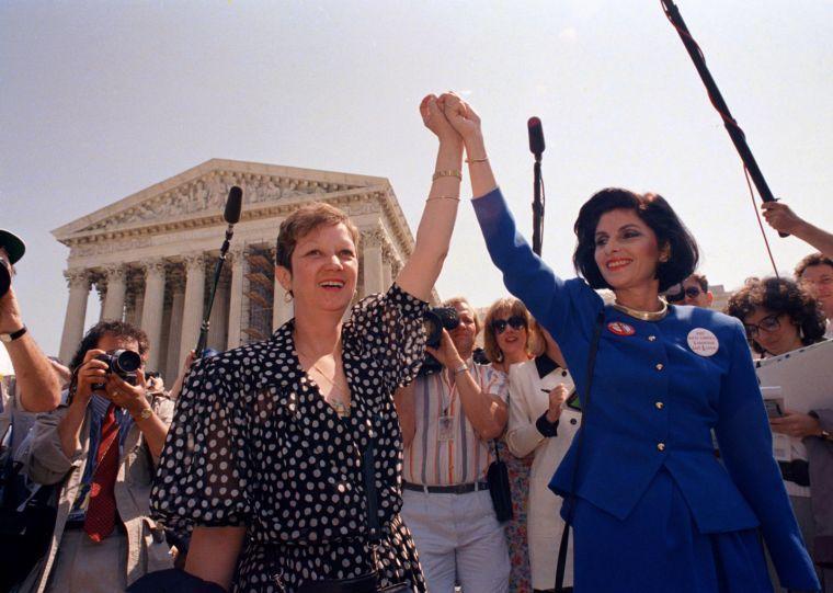 FILE - In this Wednesday, April 26, 1989 file photo, Norma McCorvey, Jane Roe in the 1973 court case, left, and her attorney Gloria Allred hold hands as they leave the Supreme Court building in Washington after sitting in while the court listened to arguments in a Missouri abortion case. Months later, the high court ultimately upheld the Missouri law in the case, Webster v. Reproductive Health Service, making it illegal to use public officials or facilities for abortions. (AP Photo/J. Scott Applewhite, File)
 