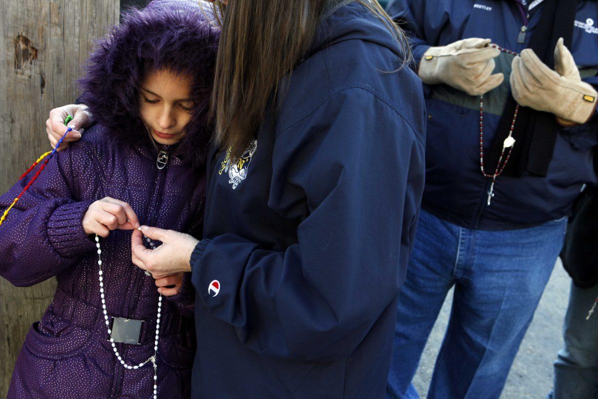 Jessica Rorke prays the rosary with her daughter Maddie Rorke, 9, at the entrance of the Routh Street Women's Clinic during the Roe Memorial Rosary/Jericho Walk to mark the 40th anniversary of the 1973 Roe v. Wade decision that legalized abortion, in Dallas on Saturday, Jan. 19, 2013. (Lara Solt/The Dallas Morning News)