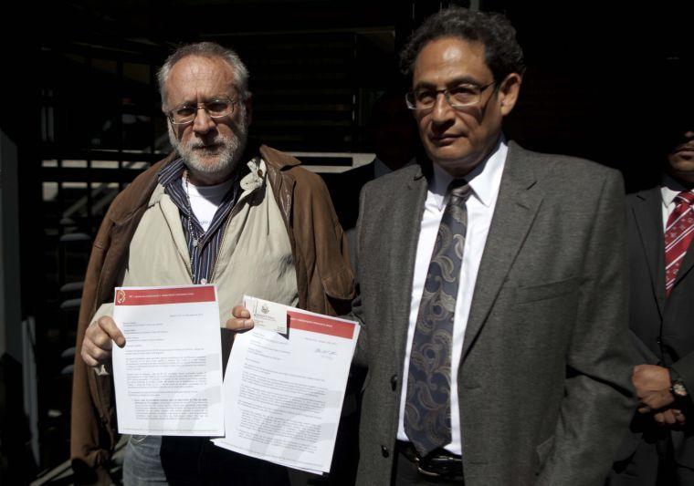 Mexican poet Javier Sicilia, leader of the Movement for Peace with Justice and Dignity, left, and activist Sergio Aguayo show a letter urging President Obama for tighter controls against gun smuggling into Mexico, outside of the U.S. Embassy in Mexico City, Monday, Jan. 14, 2013. (AP Photo/Eduardo Verdugo)
 