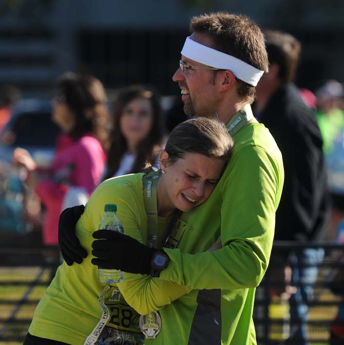 A runner consoles a fellow runner after she finishes the half-marathon and is out of breath during the Louisiana Marathon downtown on Jan. 20, 2013.
 