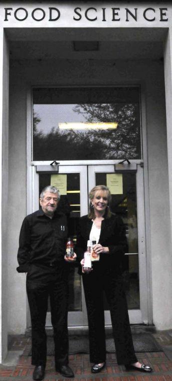 LSU AgCenter food incubator coordinator Gaye Sandoz (right) and food science professor and department head John Finley (left) pose with recent products Friday morning in front of the food science building on campus.
 