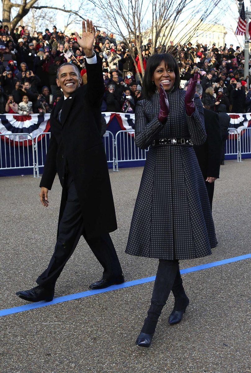 President Barack Obama and first lady Michelle Obama wave as they walk down Pennsylvania Avenue in Washington, Monday, Jan. 21, 2013, during the Inaugural Parade after his ceremonial swearing-in on Capitol Hill during the 57th Presidential Inauguration. (AP Photo/New York Times, Doug Mills, Pool)