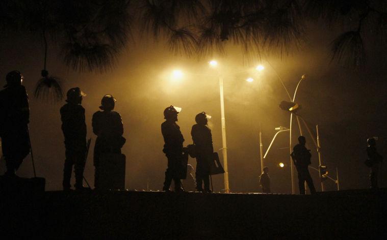 Pakistani police officers stand guards on a shipping container placed to block the supporters of Pakistani Sunni Muslim cleric Tahir-ul-Qadri, to enter into high security area Red Zone during an anti government rally in Islamabad, Pakistan Tuesday, Jan. 15, 2013. Thousands of Pakistanis fed up with political leaders they say are corrupt and indifferent rallied in the Pakistani capital Tuesday, as the fiery cleric who organized the rally called for the government to resign and for his followers to remain on the streets until then. (AP Photo/Anjum Naveed)
 