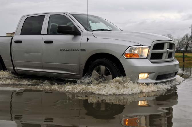 A truck drives Thursday, Jan. 10, 2013 through the flooded road near the corner of Burbank Drive and Nicholson Drive.
 