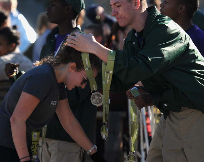 A runner accepts her medal after finishing the half-marathon at the Louisiana Marathon downtown on Jan. 20, 2013.
 