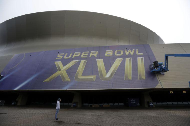 Workers put up signage for the upcoming Super Bowl on the Mercedes-Benz Superdome in New Orleans, Tuesday, Jan. 15, 2013. The NFL football Super Bowl XLVII will be held in New Orleans on Feb. 3, 2013. (AP Photo/Gerald Herbert)
 