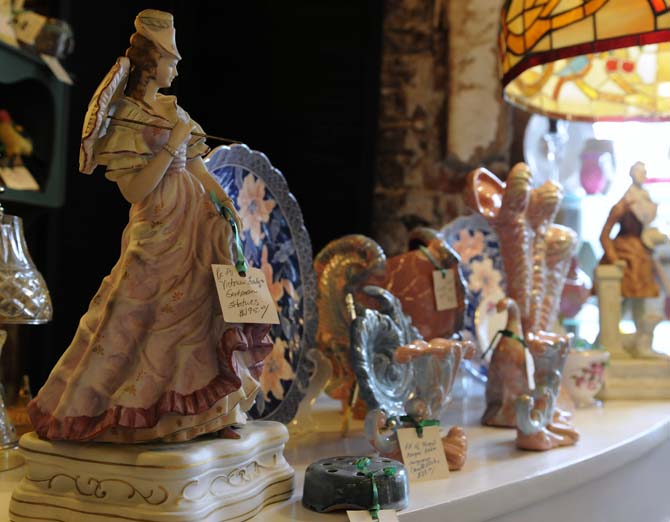 Some small Victorian statues stand illuminated by an antique lamp at the Circa 1857 shop on Jan. 28, 2013.
 