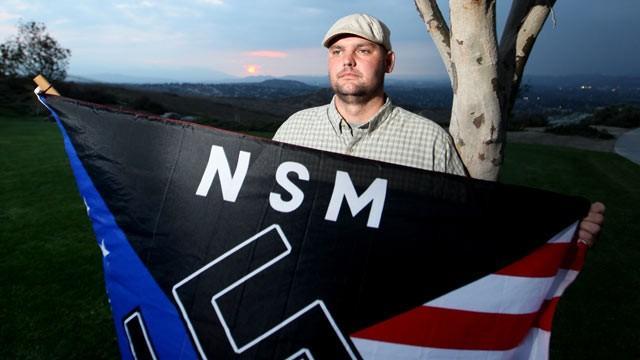 White supremacist Jeff Hall holds a Neo Nazi ag outside his California home Oct. 22, 2010. The Jewish community is one of the many cultural groups protected by the Hate Crimes Prevention Act.
 