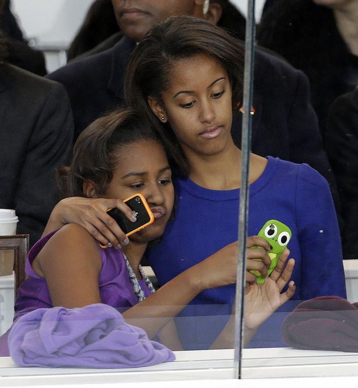 Malia Obama, right, and Sasha Obama look on from the presidential box during the Inaugural parade, Monday, Jan. 21, 2013, in Washington. Thousands marched during the 57th Presidential Inauguration parade after the ceremonial swearing-in of President Barack Obama. (AP Photo/Gerald Herbert)
 