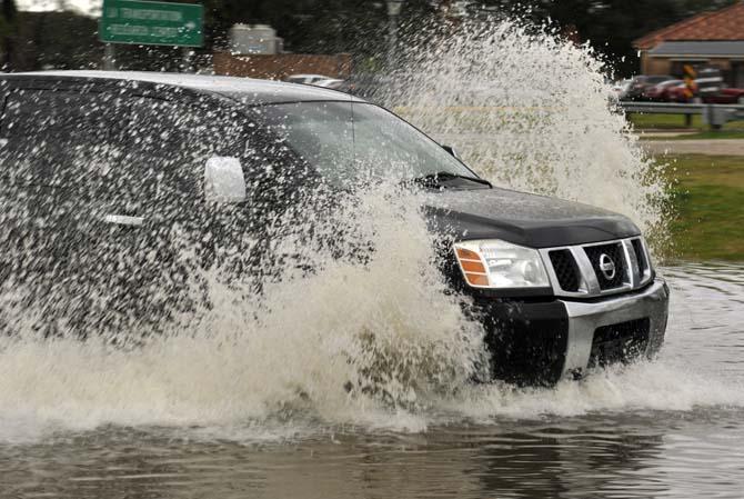 A truck drives Thursday, Jan. 10, 2013 through the flooded road near the corner of Burbank Drive and Nicholson Drive.
 