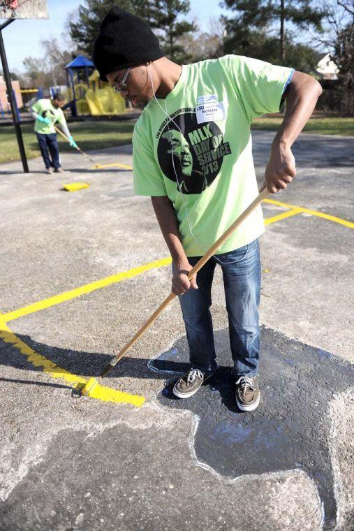 Pre-art sophomore Nicholas Belson applies paint to a basketball court outside of McKinley High School Monday Jan. 21, 2013 for the LSU Office of Multicultural Affairs MLK Day of Service 2013.
 