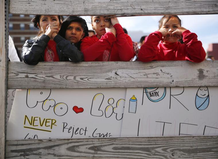 Anti-abortion supporters from St. Cecilia Catholic Church in Oak Cliff, from left, Michelle Pina, 16, Joanna Tellez, 17, Daisy Aguire, 17, and Fatima Pina, 12, gather to hear speakers at the Rally for Life outside the Earle Cabell Federal Courthouse, site of the landmark Roe v Wade lawsuit filing 40 years ago, in downtown Dallas, Saturday, Jan. 19, 2013. (AP Photo/The Dallas Morning News, Tom Fox)
 