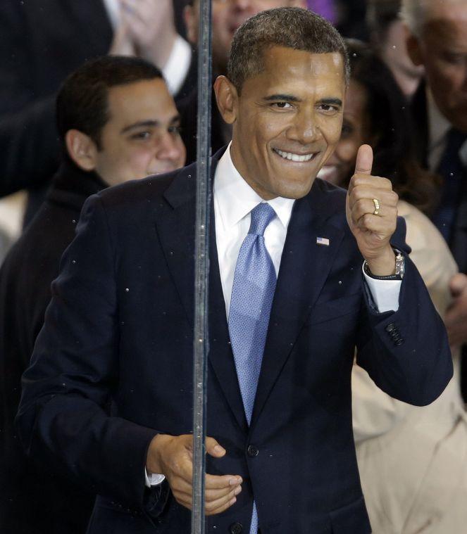 President Barack Obama gestures during the inaugural parade walk down Pennsylvania Avenue en route to the White House, Monday, Jan. 21, 2013, in Washington. Thousands marched during the 57th Presidential Inauguration parade after the ceremonial swearing-in of President Barack Obama. (AP Photo/Gerald Herbert)
 