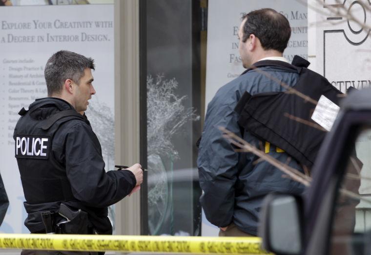 Police investigate outside the scene of a shooting Tuesday, Jan. 15, 2013, in St. Louis. Police say a gunman walked into the Stevens Institute of Business and Arts business school in downtown St. Louis and shot an administrator in the chest before shooting himself. (AP Photo/Jeff Roberson)
 