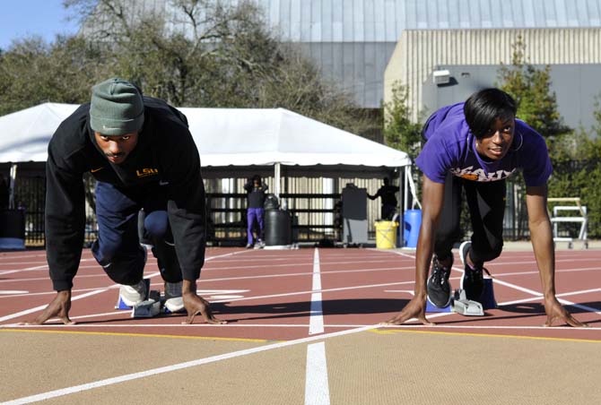 Sophomore sprinter Aaron Ernest (left) and senior sprinter Kimberlyn Duncan (right) practice at the Bernie Moore Track Stadium on Jan. 30, 2013.
 