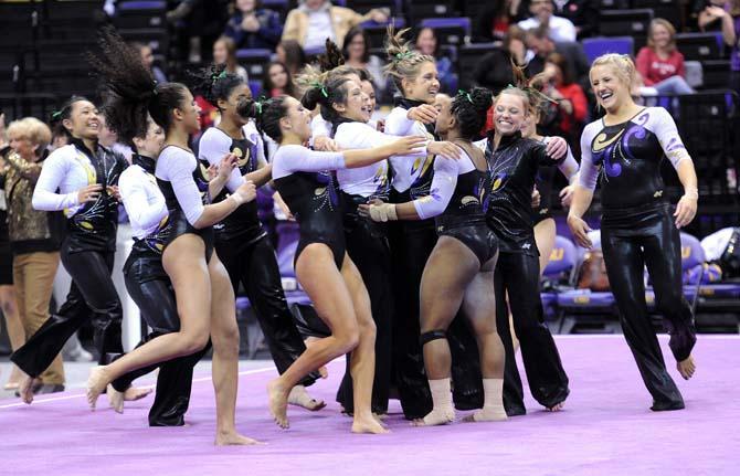 The LSU gymnastics team runs out to meet sophomore all-around Llominica Hall Jan. 4, 2013 after she completed her floor routine at the PMAC. Her score of 9.95 help secure a 196-194 victory over NC State and head coach D-D Breaux's 600th career win.
 