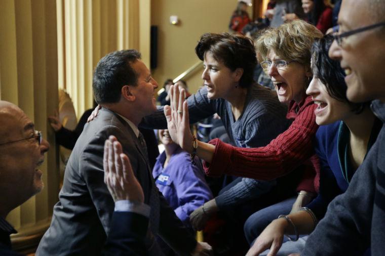 Rhode Island State Rep. Frank Ferri, D-Warwick, center left, and his partner Tony Caparco, far left, greet Wendy Baker, center right, and her partner Judy McDonnell, third from right, both of Providence, R.I., in the gallery of the House Chamber at the Statehouse, in Providence, Thursday, Jan. 24, 2013. Legislation to allow gay marriage in the state is headed for a vote Thursday in the House after being unanimously endorsed Tuesday by a legislative committee. (AP Photo/Steven Senne)
 