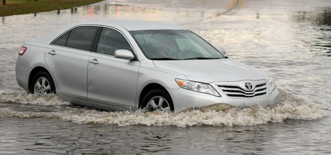 A car drives Thursday Jan. 10, 2013 through the flood waters on near the corner of Burbank Drive and Nicholson Drive.
 