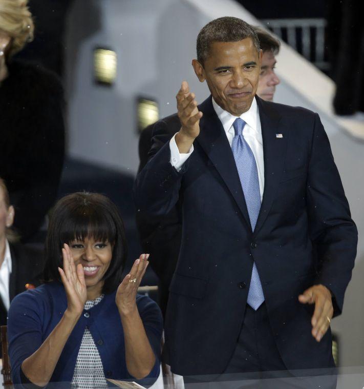 President Barack Obama and first lady Michelle Obama watch the inaugural parade, Monday, Jan. 21, 2013, in Washington. Thousands marched during the 57th Presidential Inauguration parade after the ceremonial swearing-in of President Barack Obama. (AP Photo/Gerald Herbert)
 