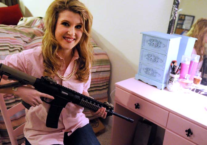 Arielle Sutton, a junior agricultural business major, holds her Smith &amp; Wesson&#8217;s M&amp;P 15-22 rifle in her Tiger Manor apartment on Jan. 14, 2013.
 