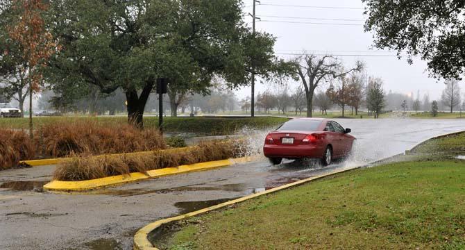 A car splashes through standing water Jan. 9, 2013 near Nicholson Drive. Heavy rain flooded several areas near the University.
 