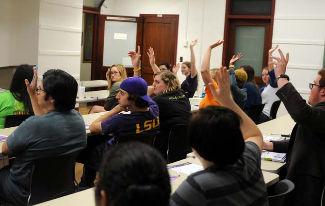 Students raise their hands on Monday, Jan. 28, 2013 at a meeting for the Geography and Anthropology Society in the Howe Russell Geoscience Complex.
 