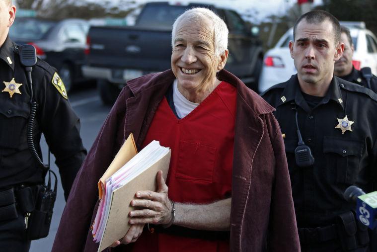 FILE - In this Jan. 10, 2013 file photo, former Penn State University assistant football coach Jerry Sandusky, center, arrives at the Centre County Courthouse for a post-sentence motion in Bellefonte, Pa. Sandusky lost a bid for a new trial Wednesday, Jan. 30, 2013 when Judge John Cleland rejected his argument that his lawyers were not given enough time to prepare for the three-week proceeding that ended with a 45-count guilty verdict. Sandusky is serving a 30- to 60-year prison sentence after being convicted in June of 45 counts of child sexual abuse. (AP Photo/Gene J. Puskar, File)
 