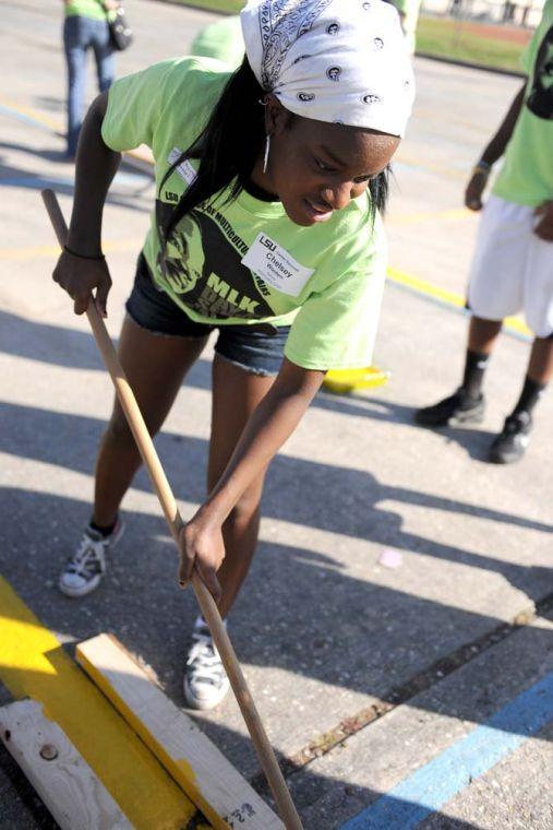 Psychology senior Chelsey Wooten applies paint to a parking spot outside of McKinley High School Monday Jan. 21, 2013 for the LSU Office of Multicultural Affairs MLK Day of Service 2013.
 