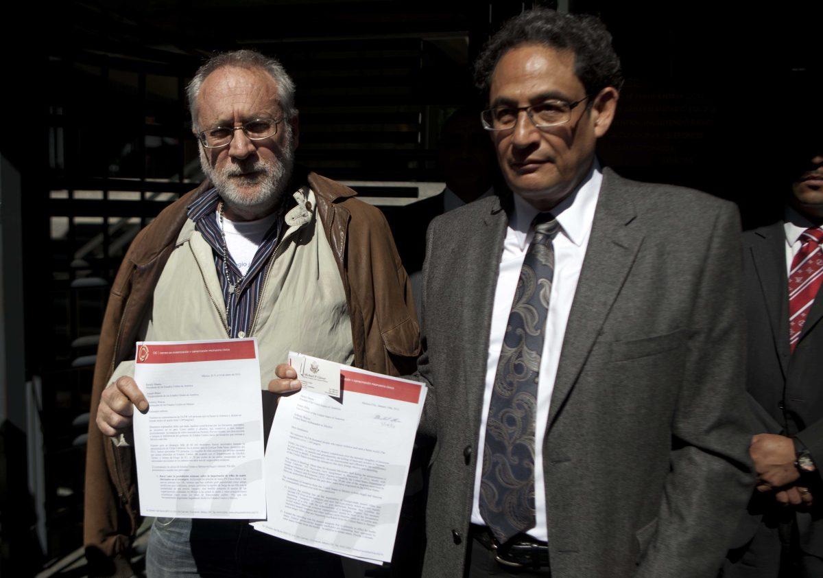 Mexican poet Javier Sicilia, leader of the Movement for Peace with Justice and Dignity, left, and activist Sergio Aguayo show a letter urging President Obama for tighter controls against gun smuggling into Mexico, outside of the U.S. Embassy in Mexico City, Monday, Jan. 14, 2013. (AP Photo/Eduardo Verdugo)