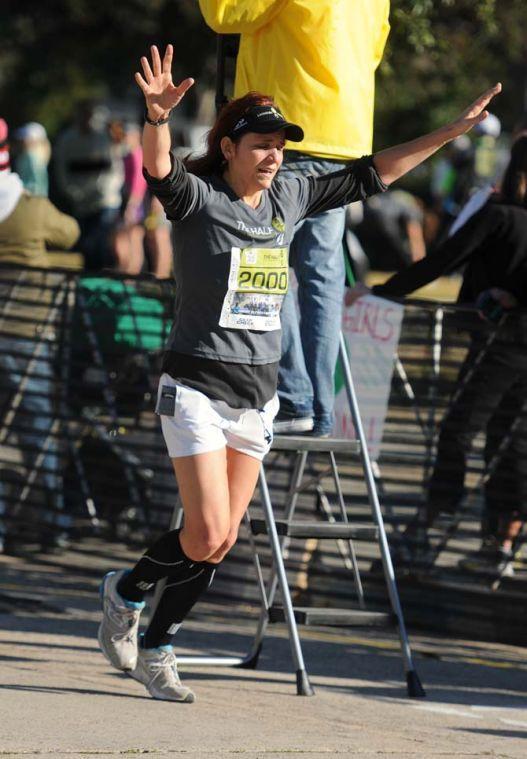 A runner puts her hands above her head in triumph as she comes across the half-marathon finish line as a part of the Louisiana Marathon downtown on Jan. 20, 2013.
 