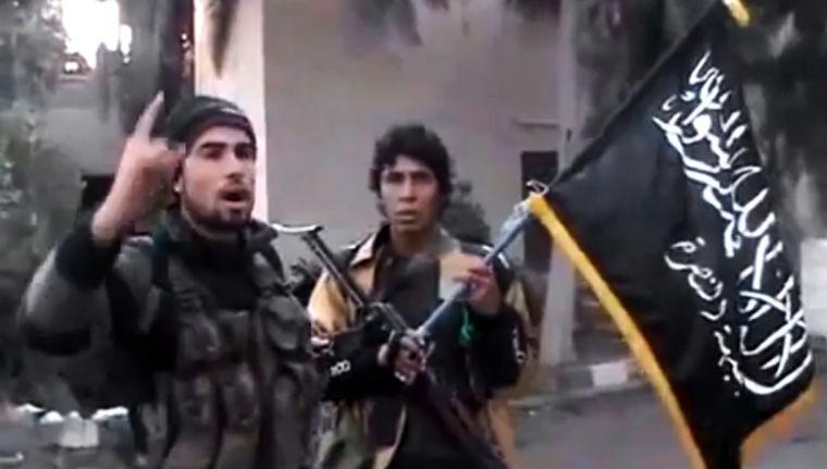 In this image taken from video obtained from the Ugarit News, which has been authenticated based on its contents and other AP reporting, a Free Syrian Army fighter speaks in front of a government intelligence complex in Deir el-Zour, Syria, on Tuesday, Jan. 29, 2012. Syrian rebels stormed a government intelligence complex in the oil-rich east of the country on Tuesday, freeing at least 11 people held in a prison at the facility, activists said. (AP Photo/Ugarit News via AP video)
 