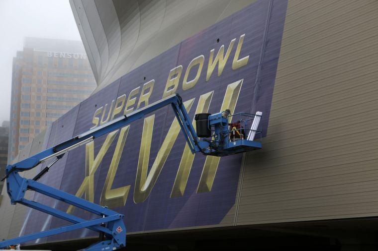 Workers put up signage for the upcoming Super Bowl on the Mercedes-Benz Superdome in New Orleans, Tuesday, Jan. 15, 2013. The NFL football Super Bowl XLVII will be held in New Orleans on Feb. 3, 2013. (AP Photo/Gerald Herbert)
 