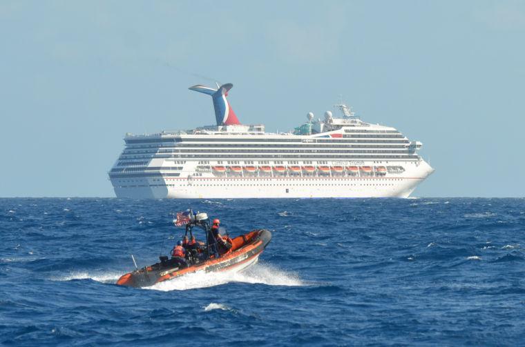 In this image released by the U.S. Coast Guard on Feb. 11, 2013, a small boat belonging to the Coast Guard Cutter Vigorous patrols near the cruise ship Carnival Triumph in the Gulf of Mexico, Feb. 11, 2013. The Carnival Triumph has been floating aimlessly about 150 miles off the Yucatan Peninsula since a fire erupted in the aft engine room early Sunday, knocking out the ship's propulsion system. No one was injured and the fire was extinguished. (AP Photo/U.S. Coast Guard- Lt. Cmdr. Paul McConnell)
 