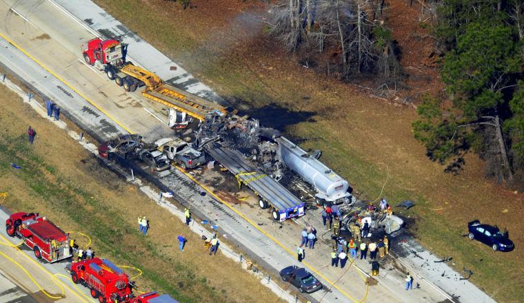 Emergency workers and firemen are at he scene of a pile up on Interstate 16 near Jeffersonville, Ga., Wednesday Feb. 6, 2013. More than two dozen vehicles collided in a fiery pileup on the foggy Georgia interstate on Wednesday morning, killing at least three people and leaving several others hurt, officials said. (AP Photo/The Macon Telegraph, Woody Marshall)
 