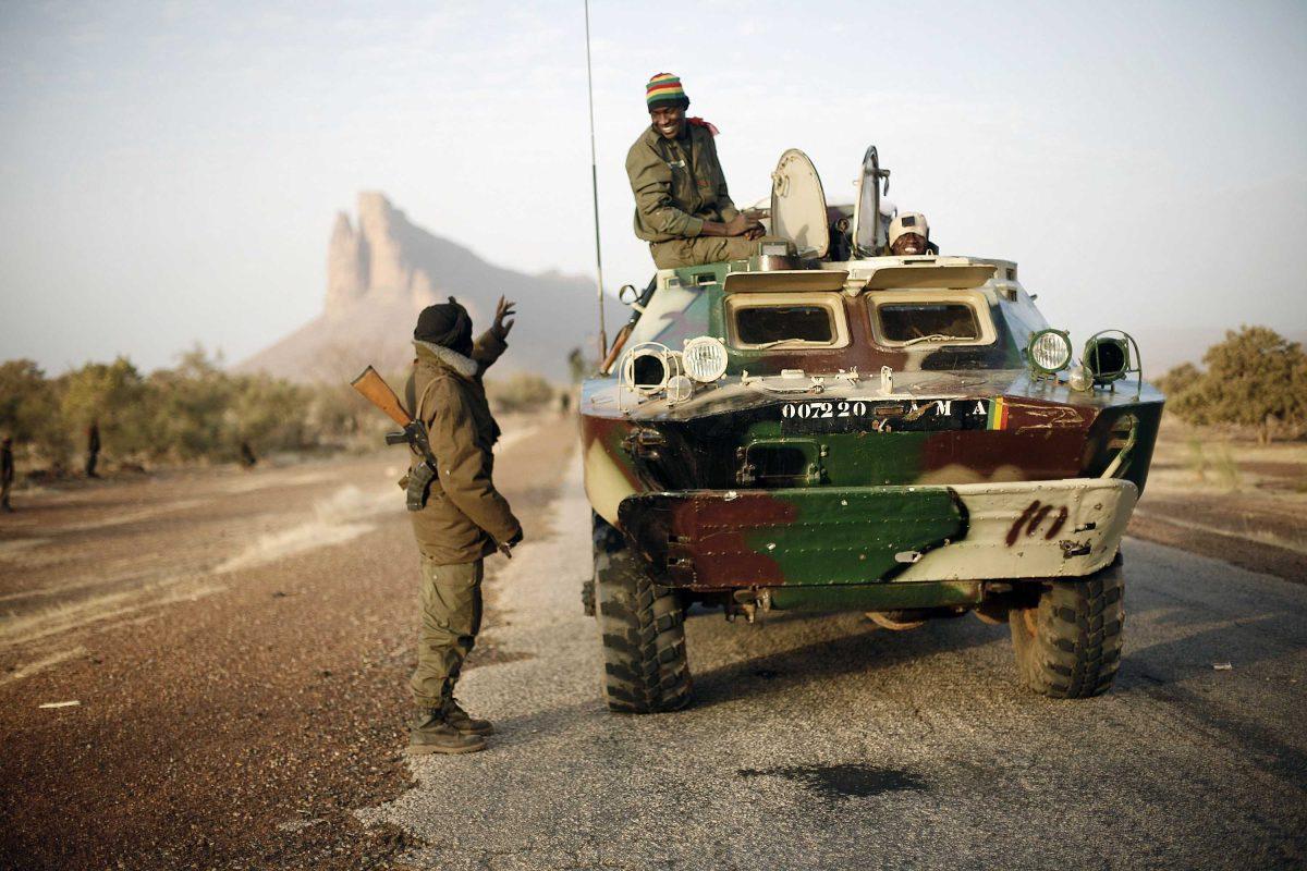 A convoy of Malian troops makes a stop to test some of their weapons near Hambori, northern Mali, on the road to Gao, Monday Feb. 4, 2013. French troops launched airstrikes on Islamic militant training camps and arms depots around Kidal and Tessalit in Mali's far north, defense officials said Sunday, as the first supply convoy of food, fuel and parts to eastern Mali headed across the country. (AP Photo/Jerome Delay)