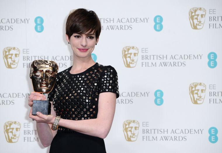 American actress Anne Hathaway poses backstage with the award for Supporting Actress for her role in "Les Miserables," at the BAFTA Film Awards at the Royal Opera House on Sunday, Feb. 10, 2013, in London. (Photo by Jonathan Short/Invision/AP)
 