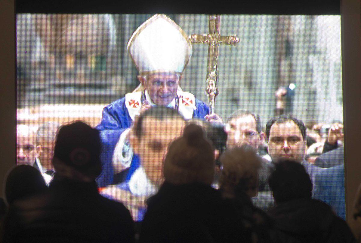 Faithful watch a giant screen placed under the statue of St. Peter, in St. Peter's Square at the Vatican, showing Pope Benedict XVI celebrating the Ash Wednesday mass in St. Peter's Basilica, Wednesday, Feb. 13, 2013. With a few words in Latin, Pope Benedict XVI did what no pope has done in more than half a millennium, stunning the world by announcing his resignation Monday and leaving the already troubled Catholic Church to replace the leader of its 1 billion followers by Easter. (AP Photo/Domenico Stinellis)